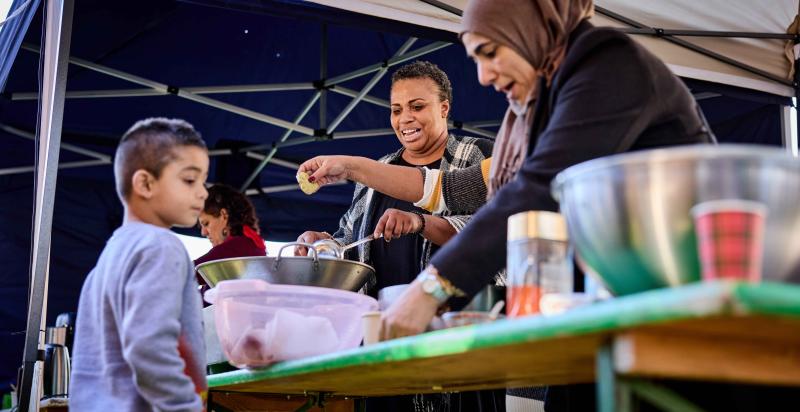 Twee vrouwen serveren eten aan een kind