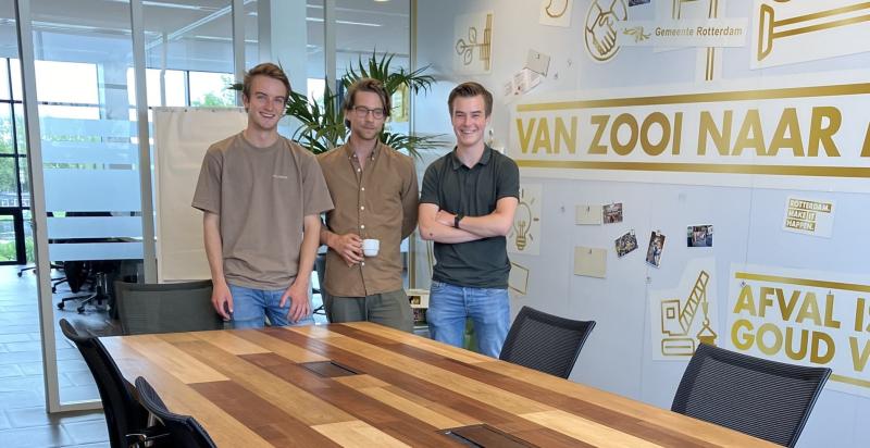 De drie studenten Elmar, Mels en Kaz staan achter hun zelf ontworpen vergadertafel.