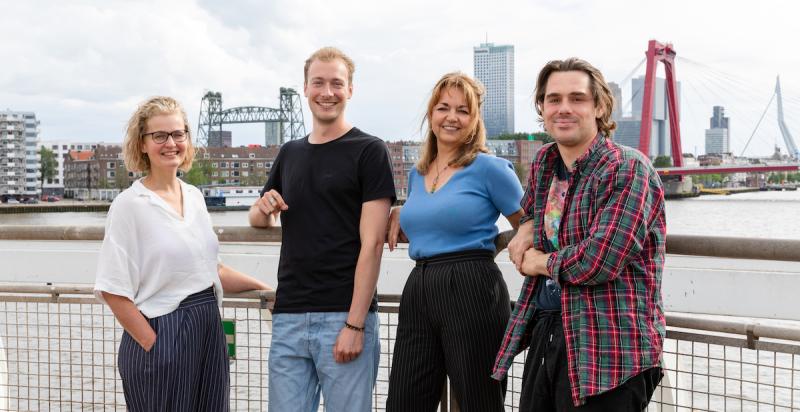 Vier personen met op de achtergrond de Maas, de Erasmusbrug, Willemsbrug en De Hef.