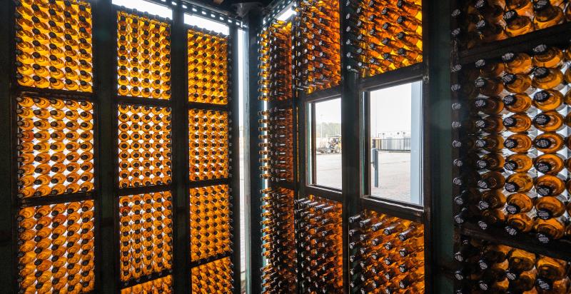 Binnenkant van een werkruimte in circulair gebouw De HER. De wanden zijn volledig opgebouwd uit lege bierflesjes