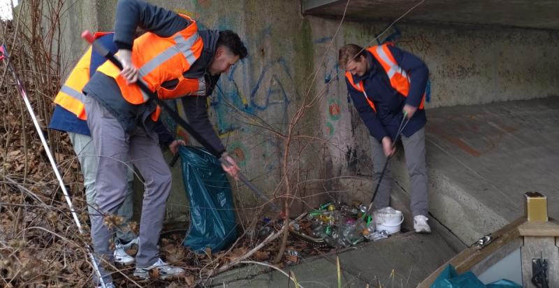 Twee mannen prikken vuilnis op 