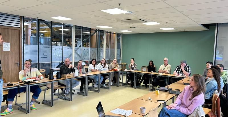 Festivalorganisatoren zitten in zaal en volgen workshop