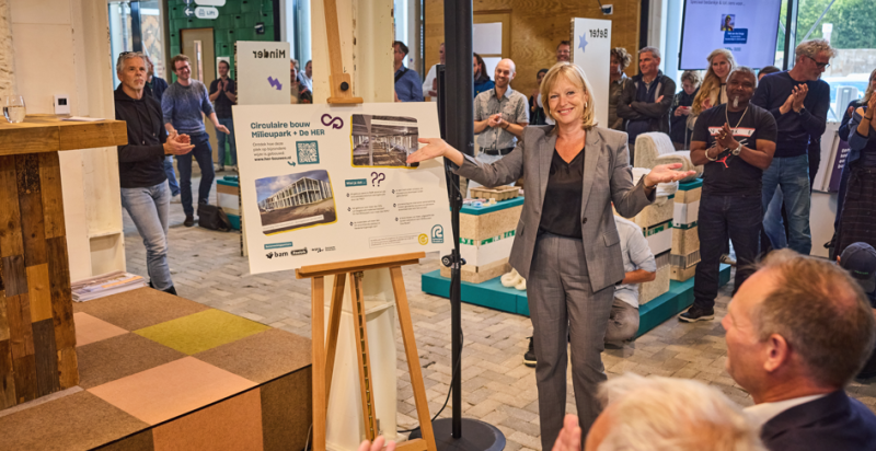 Wethouder Zeegers presenteert een informatiebord in circulair centrum De HER