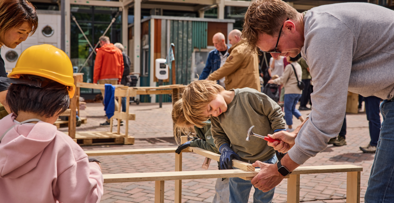 man en twee kinderen slaan met een hamer