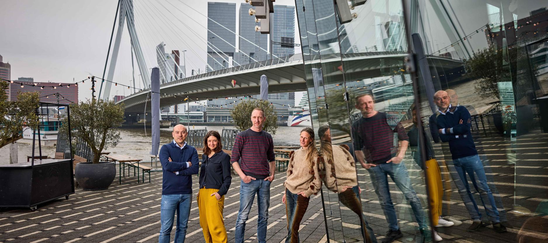 vier mensen poseren voor de erasmusbrug