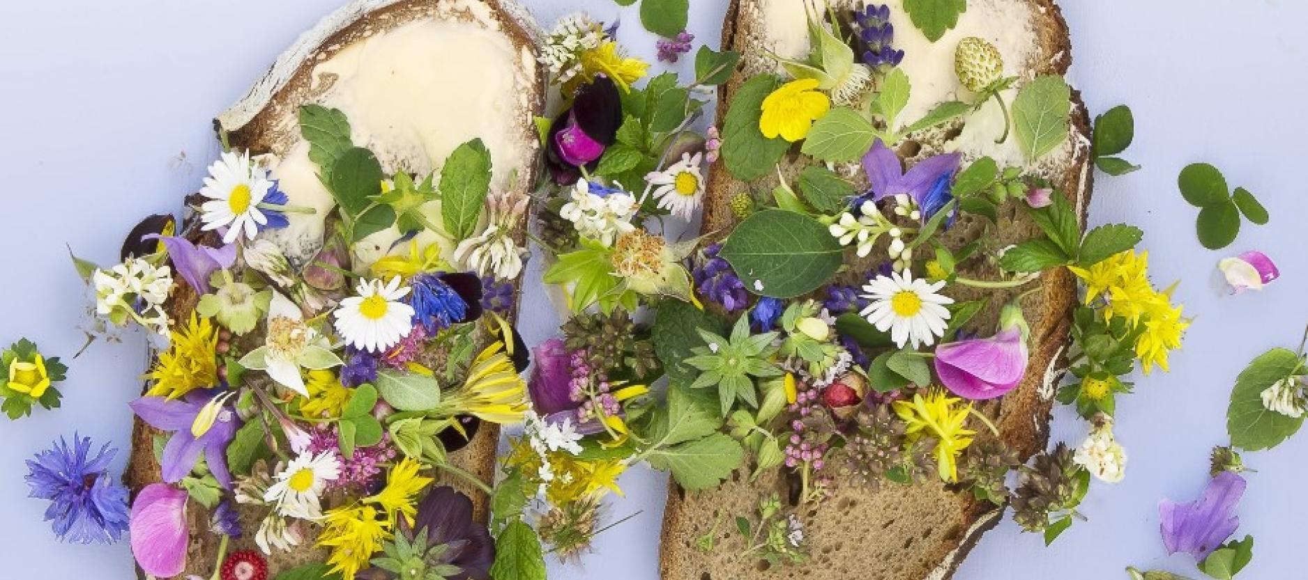 Twee bruin boterhammen belegd met kleurrijke bloemen en blaadjes