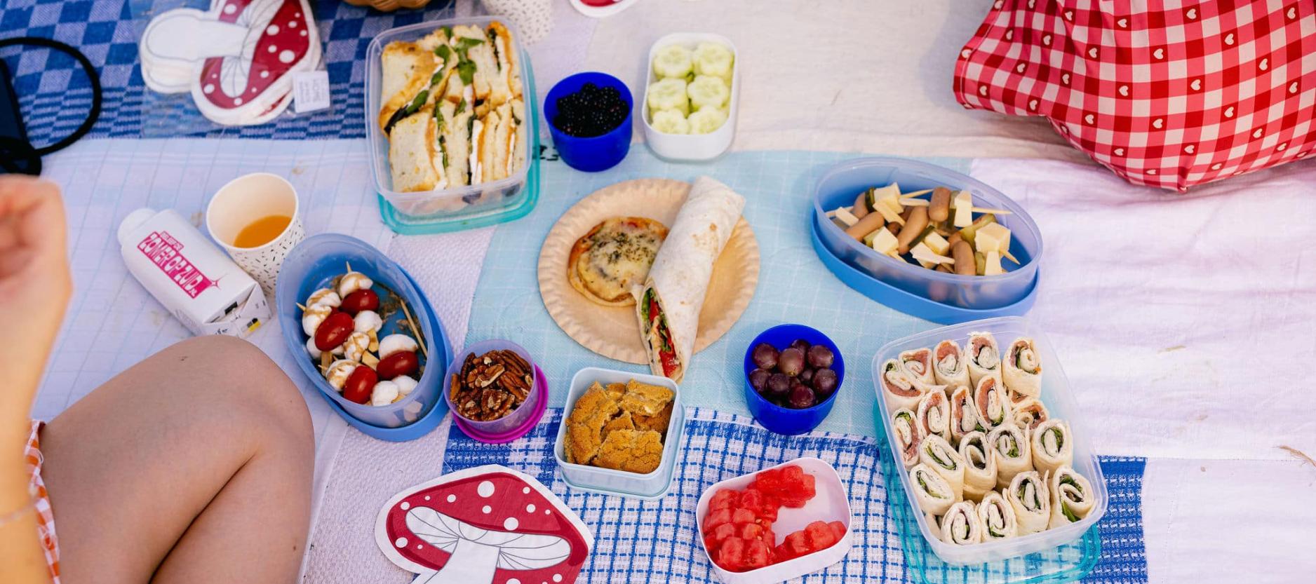 Eten in bakjes uitgestald op een picknick kleed