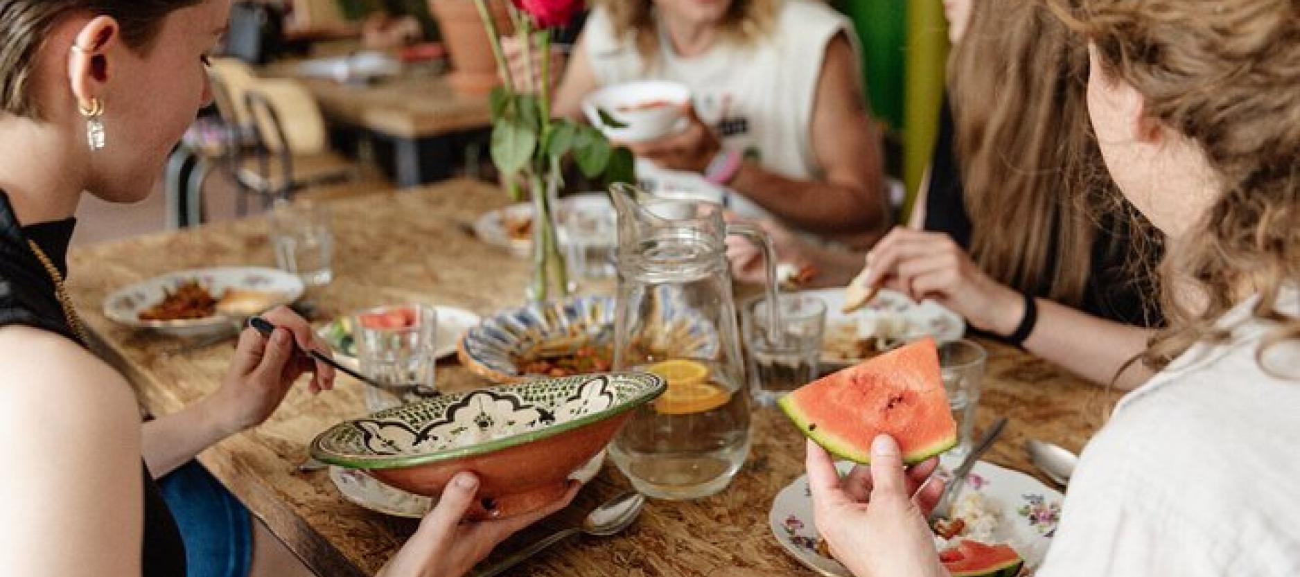 Vier mensen dineren aan tafel