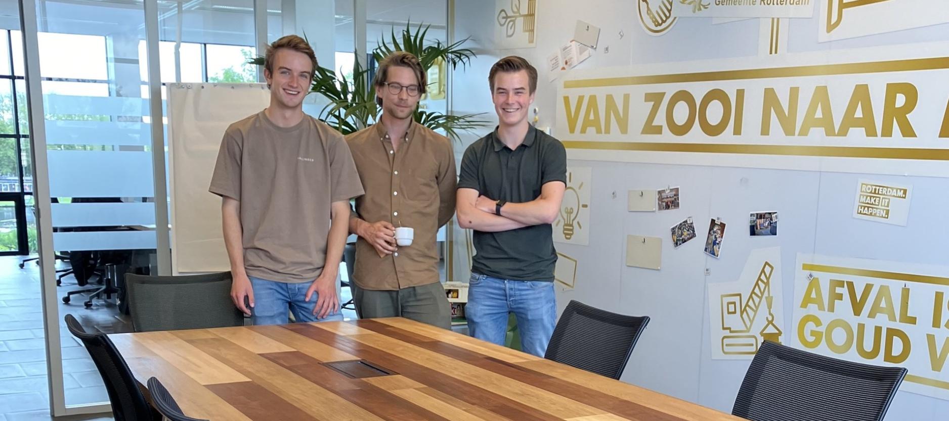 De drie studenten Elmar, Mels en Kaz staan achter hun zelf ontworpen vergadertafel.