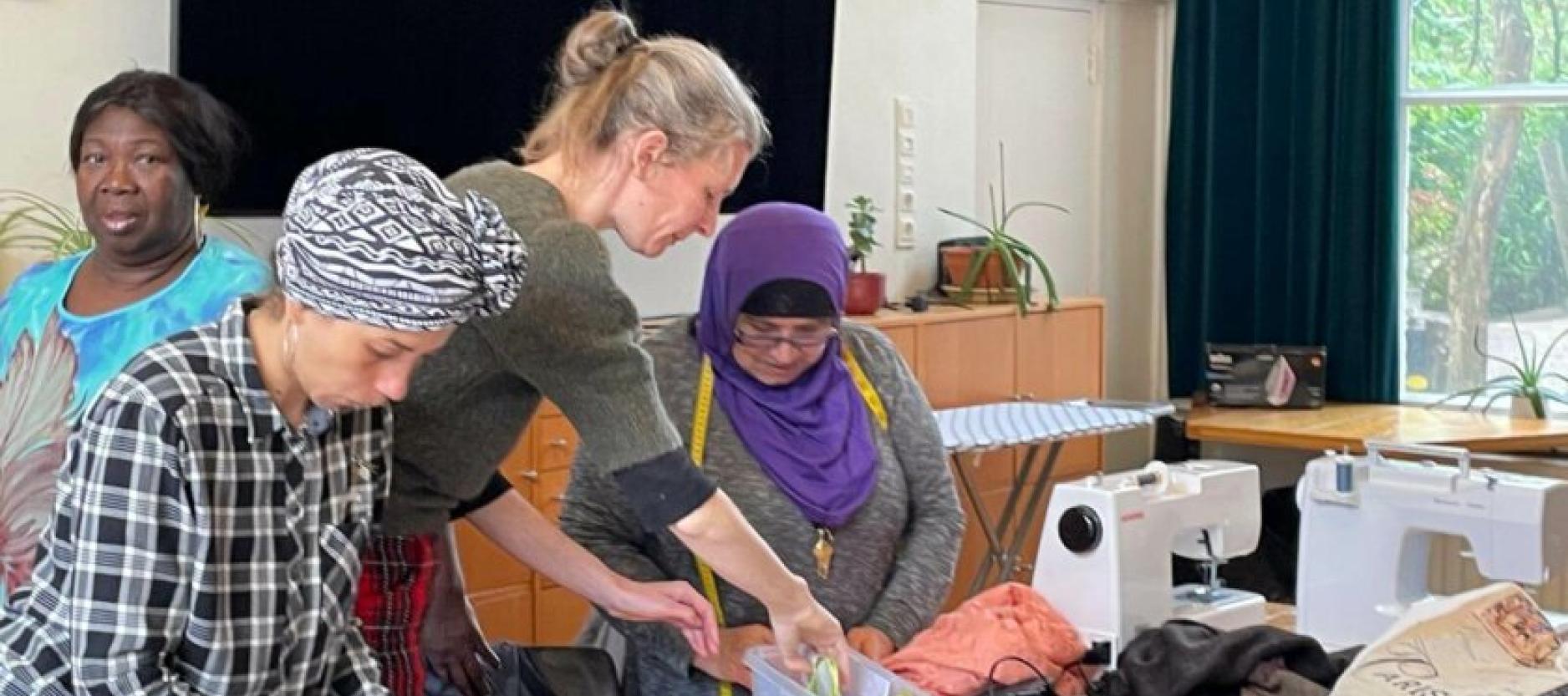 vier vrouwen aan het werk met een naaimachine en textiel