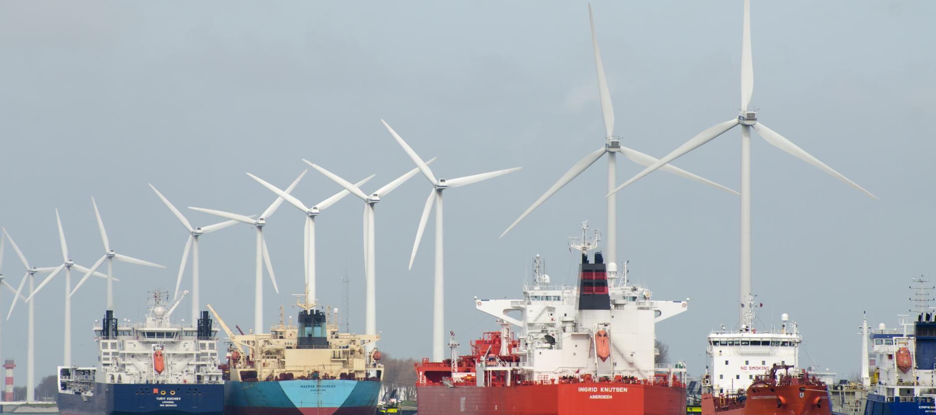 Stukje Rotterdamse haven met schepen en een rij windmolens