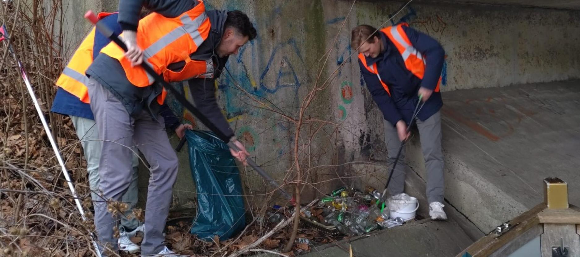 Twee mannen prikken vuilnis op 