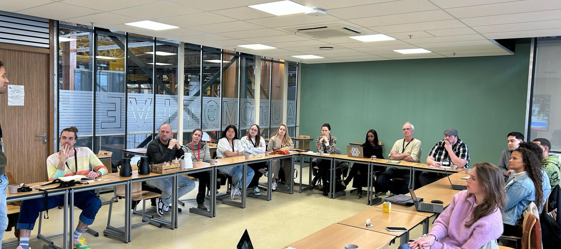 Festivalorganisatoren zitten in zaal en volgen workshop