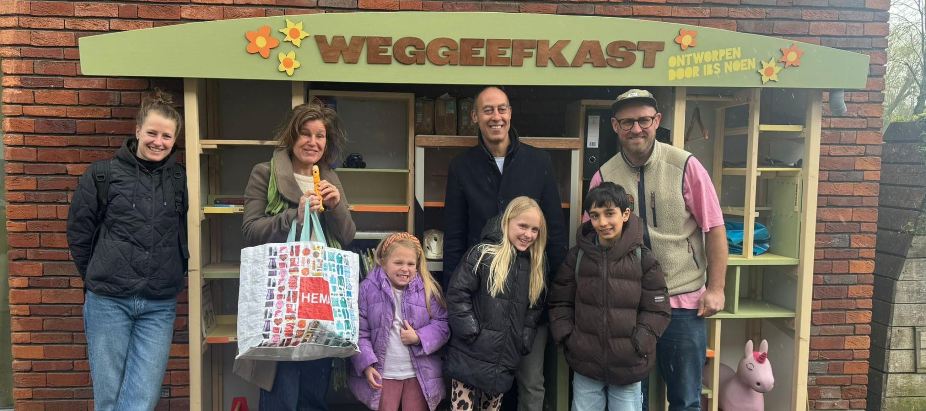 Groep mensen poseren voor de weggeefkast