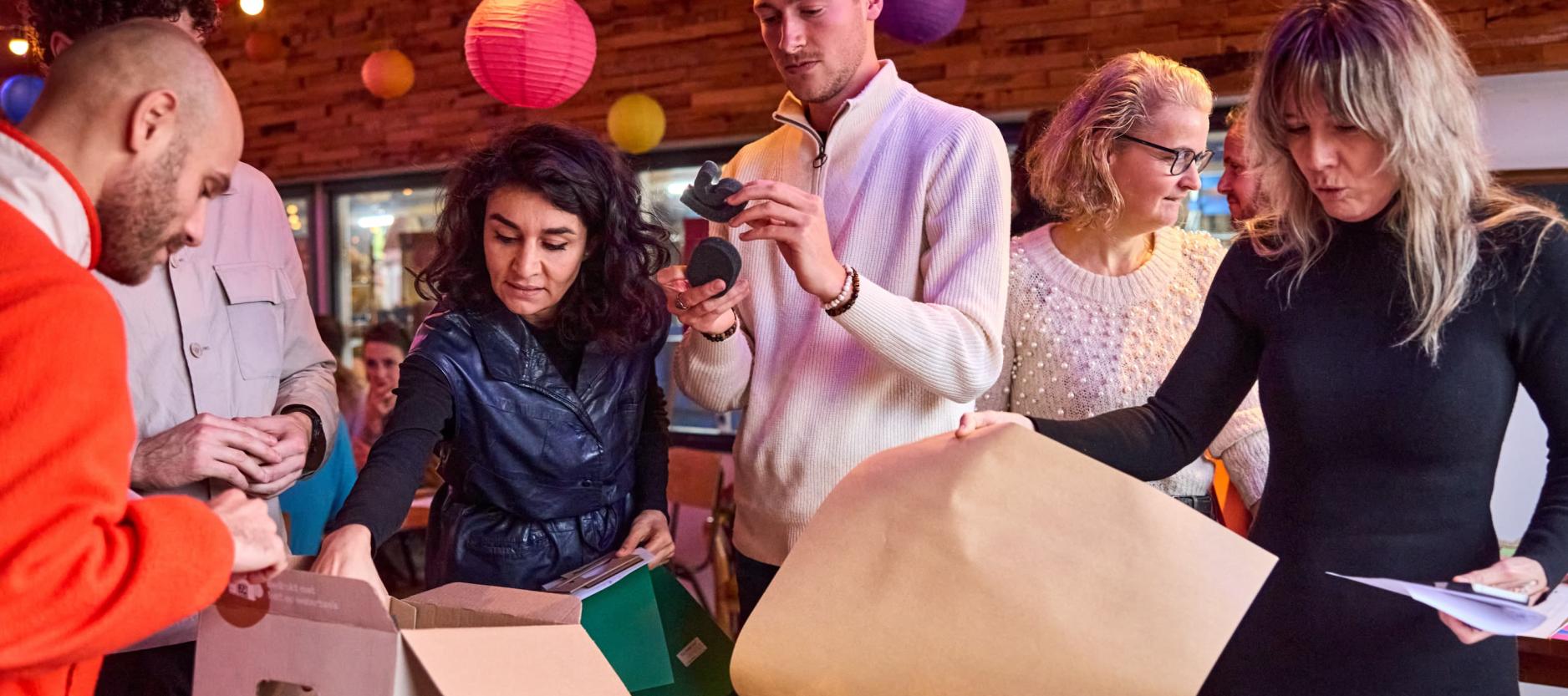 Groepje mensen staat rond een tafel voor een workshop