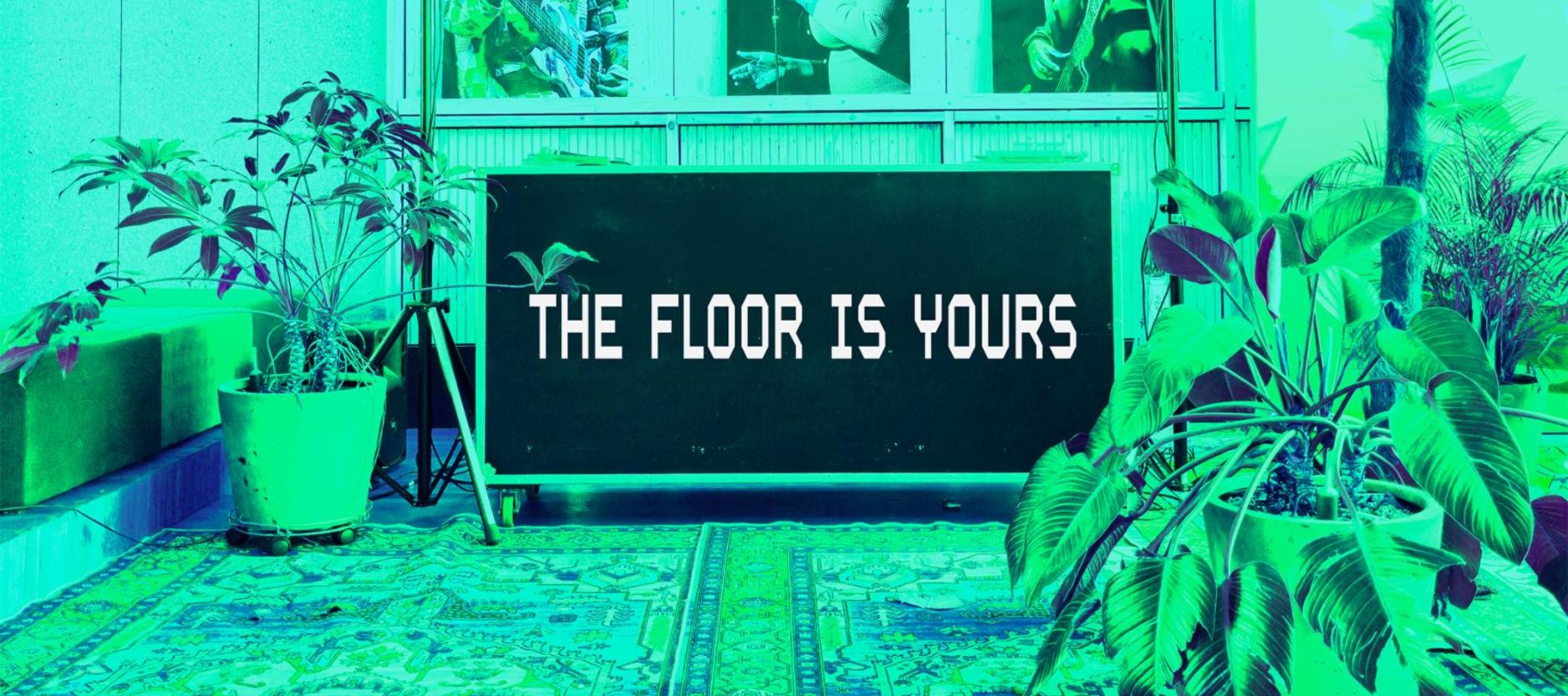 Tekst The Floor Is Yours op een bord in een kamer voorzien van planten en kleden