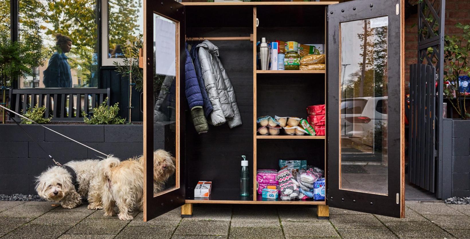 Een kijkje in een weggeefkast gevuld met kinderkleding, etenswaren en hygieneproducten