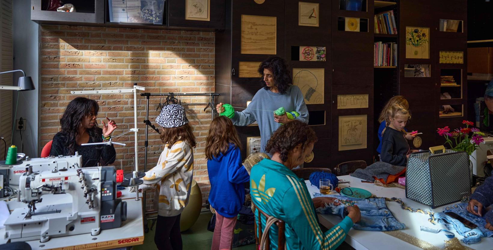 een klas kinderen krijgt naailes