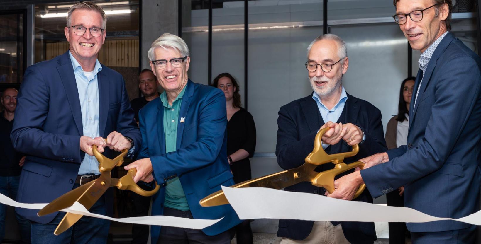 Arno van Prooijen, directeur Openbare Werken van de gemeente Rotterdam, Wim van Heemst van hoogheemraadschap van Schieland en de Krimpenerwaard en Anne Mollema van waterschap Hollandse Delta houden in tweetallen twee grote gouden scharen vast en knippen een breed wit lint door.