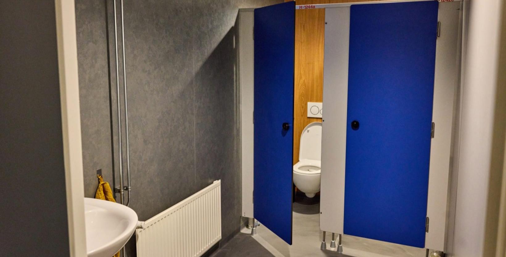 Op de foto de toiletruimte van Honkbalverening Op Zuid met de blauwe herbruikte deuren van het Erasmus MC