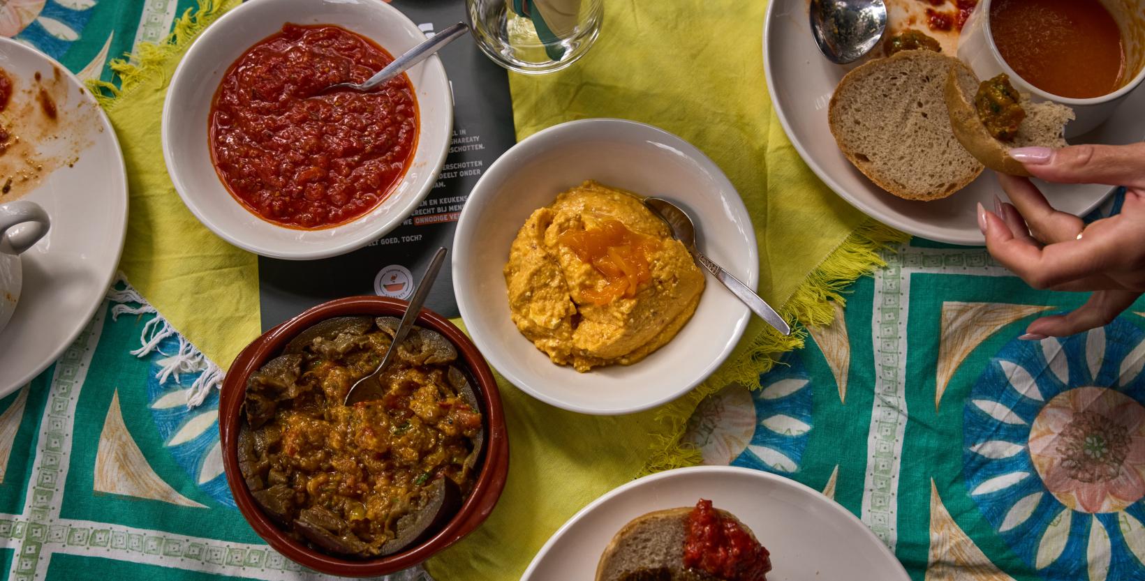 Een tafel met daarop een paar schaaltjes met dips gemaakt van geredde groenten.
