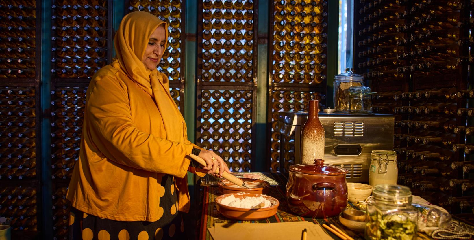 Vrouw is brood aan het maken in één van de boxen van circulair centrum De HER.